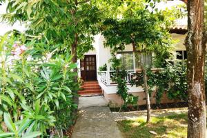 a house with a porch with trees and a staircase at Vila Vasi- Μodern maisonette view Meteora in Kastraki