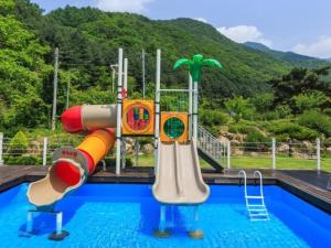 a swimming pool with a water park with a slide at Wonju Cloud Pension in Wonju