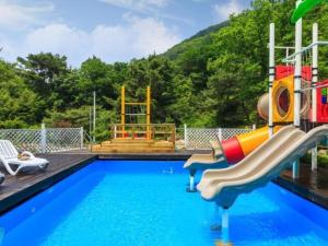 a pool with a slide and a playground at Wonju Cloud Pension in Wonju