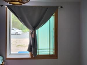 a window with a black curtain in a room at Geoje Milky Way Pension in Geoje