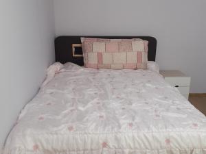 a bed with pink and white sheets and pillows at Geoje Milky Way Pension in Geoje