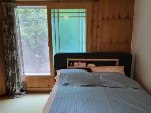 a bedroom with a bed with a large window at Geoje Milky Way Pension in Geoje