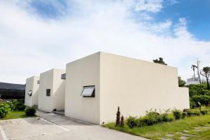 a white house with a courtyard at Seogwipo Jan-Jan Pension in Seogwipo