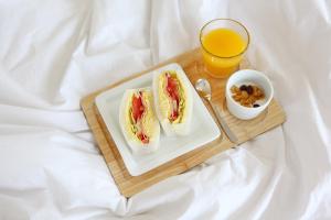 a tray with two hot dogs and a glass of orange juice at Seogwipo Jan-Jan Pension in Seogwipo