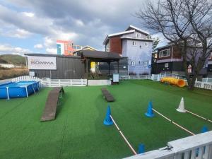 a playground with artificial grass and blue cones at Gyeongju Heimisch Pool Villa in Gyeongju