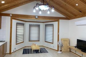 a living room with a table and some windows at Pyeongchang underhill pension in Pyeongchang