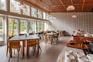 a restaurant with tables and chairs and windows at Stayokay Hostel Apeldoorn - Fully renovated March 2026 in Apeldoorn