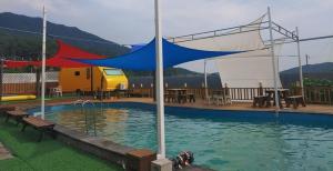 a tent over a swimming pool with a table and tables at Jnj Village in Suncheon
