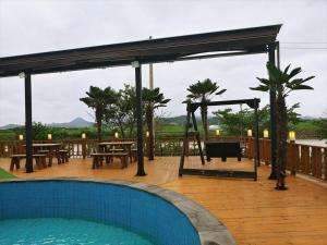 a pavilion with a pool and tables on a deck at Jnj Village in Suncheon