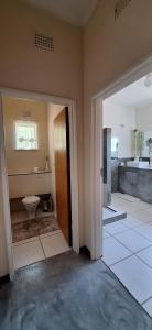 an empty bathroom with a toilet and a sink at Mitat Guesthouse in Beaufort West