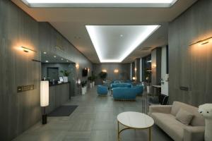 a lobby with a waiting room with blue chairs and a couch at CL Hotel in Boryeong +24 photos