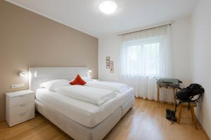 a white bedroom with a large bed and a window at Villa Sabine in Merano +59 photos