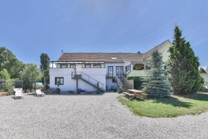 a large white house with a gravel yard at Gites Bretzel Cigogne ET Manala in Munwiller