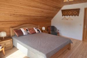 a bedroom with a bed and a wooden ceiling at Pamiškės Villa in Kulautuva