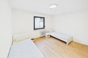 a white room with two beds and a window at Ankas Ferienwohnung 2 in Bexbach