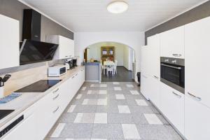 a kitchen with white cabinets and a checkered floor at Ankas Ferienwohnung 2 in Bexbach