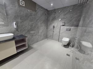 a bathroom with a shower and a sink and a toilet at HOTEL AYUSHMAN in Varanasi +24 photos