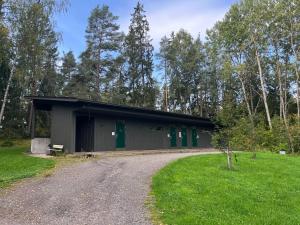 a building with green doors and a gravel road at Vuohensaari, Rantatalo 3 in Salo