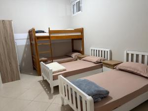 a room with three bunk beds and a ladder at Exeas Hostel in Vlorë +14 photos