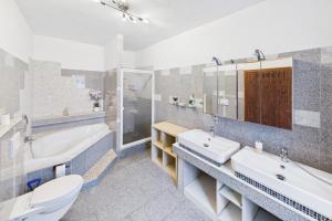 a bathroom with two sinks and a tub and a toilet at Ankas Ferienwohnung 2 in Bexbach