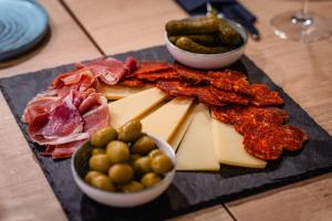 a plate of cheese and meats and pickles on a table at Villa Nautica Stone House in Split