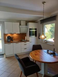 a kitchen with a wooden table and a dining room at Gemütliches Häuschen am Fleesensee in Göhren-Lebbin