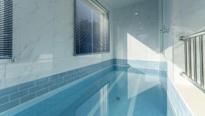 a swimming pool in a bathroom with blue tile at Gapyeong Zav Pool Villa in Gapyeong