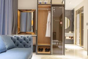 a living room with a couch and a mirror at Gimhae Eobang-Dong Nomad Hotel in Gimhae