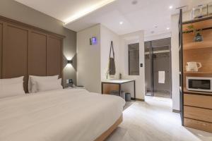 a bedroom with a large white bed and a television at Gimhae Eobang-Dong Nomad Hotel in Gimhae +17 photos