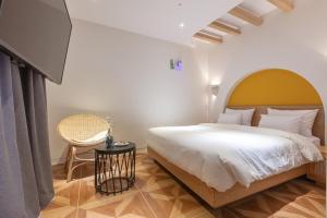 a bedroom with a large white bed and a chair at Gimhae Eobang-Dong Nomad Hotel in Gimhae