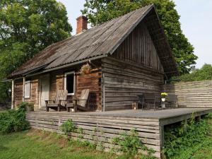 a log cabin with a porch and chairs on a deck at PLŪSME Restart House in Lielstraupe