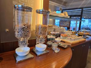 a counter with two tall glass containers filled with food at Euro Hotel in Edolo +16 photos