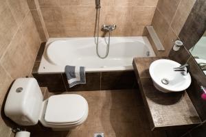 a bathroom with a toilet and a tub and a sink at Venetia Luxurious Villa in Iraklitsa +18 photos