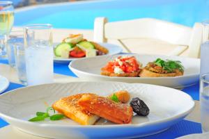 a table with three plates of food on it at Stefanos Village Hotel in Plakias