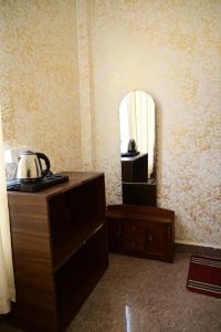 a room with a dresser and a mirror on the wall at Maa Mandakini Resort & Hotel in Chitrakoot