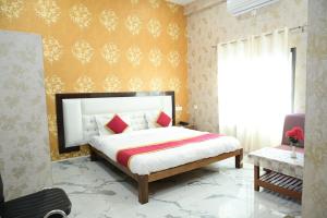 a bedroom with a bed and a yellow wall at Maa Mandakini Resort & Hotel in Chitrakoot