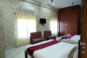 a hotel room with a bed and a chair at Maa Mandakini Resort & Hotel in Chitrakoot +9 photos