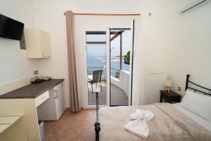 a room with a bed and a view of the ocean at ARTEMIS ROOMS in Pefki