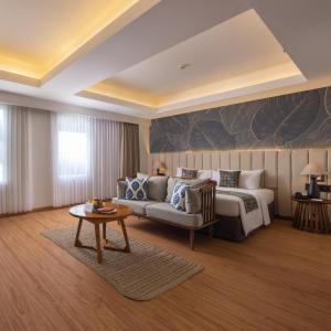 a hotel room with a bed and a couch at Crystalkuta Hotel - Bali in Kuta +74 photos