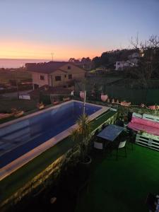 a view of a swimming pool with a table and chairs at O refuxio do mar in Oia