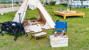 a tent with chairs and a table and a stroller at Glamdog - Tongyeong Pet-friendly in Tongyeong