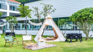 a tent in the grass in front of a building at Glamdog - Tongyeong Pet-friendly in Tongyeong