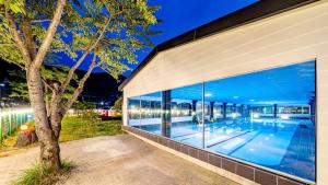 a building with a large window with a swimming pool at Glamdog - Tongyeong Pet-friendly in Tongyeong