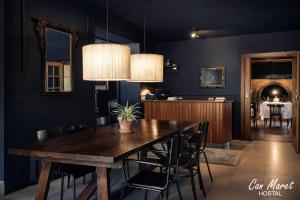 a dining room with a wooden table and black walls at Hostal Can Maret in Vilademuls