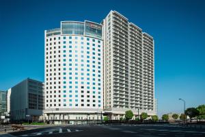 a tall white building with a lot of windows at Hilton Garden Inn Yokohama Minatomirai in Yokohama