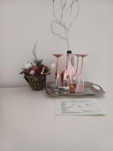 a table with three vases and a paper and flowers at Pensiunea Izabel in Lacu Rosu