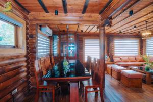 a dining room with a table and a couch at Ume Villa & Retreat in Bóng Suối