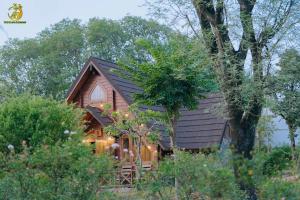 a cabin in the woods with a black roof at Ume Villa & Retreat in Bóng Suối