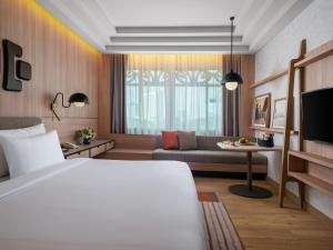 a hotel room with a bed and a couch at Grand Inna Tunjungan Hotel Surabaya in Surabaya