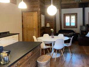 a kitchen and living room with a table and chairs at Chalet Les Ravaires, Morgins in Troistorrents
